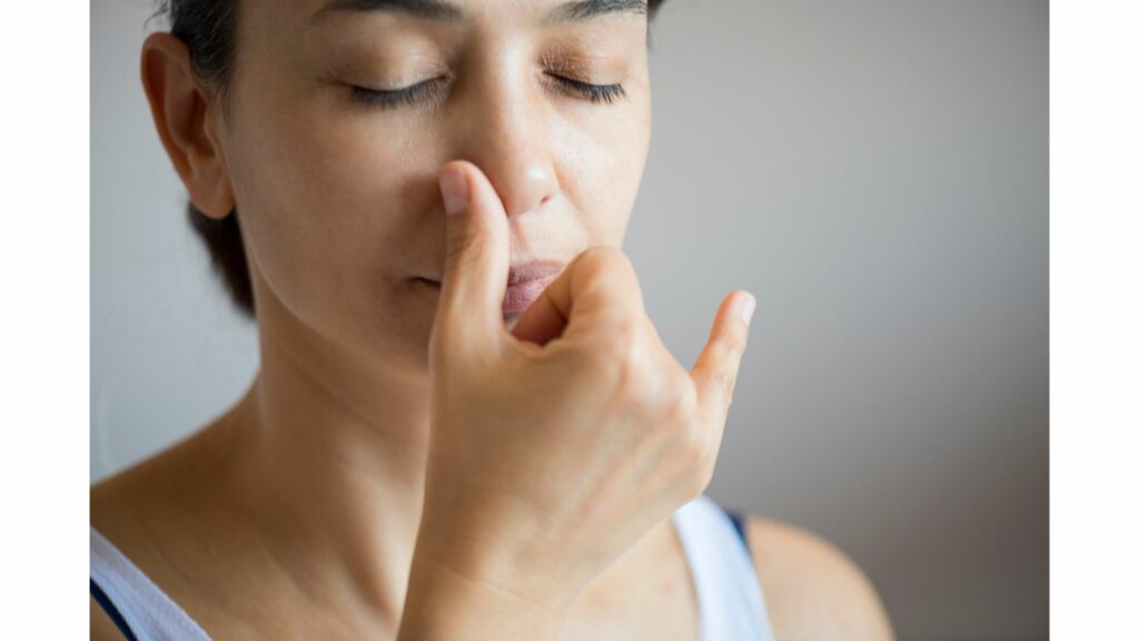 Woman demonstrates alternate nostril breathing for better sleep