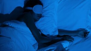 Middle aged woman sleeping in a dark room with eye mask