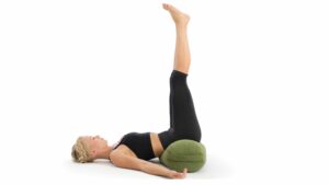 Restorative Yoga for sleep - a woman demonstrates legs up the wall, Viparita Karani